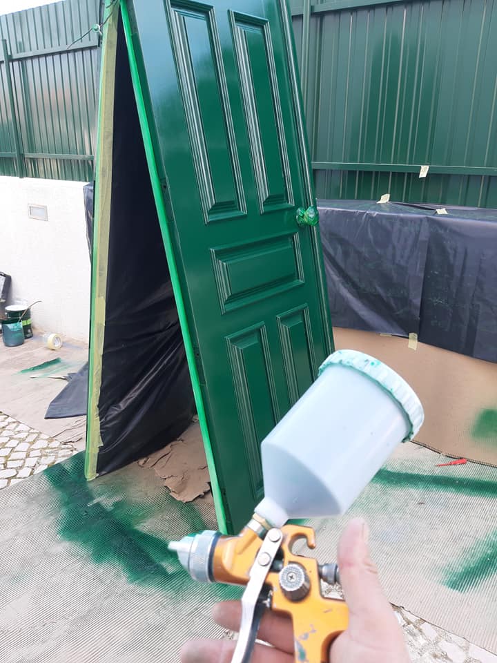 Pintura de uma porta à pistola, em trabalho no exterior
