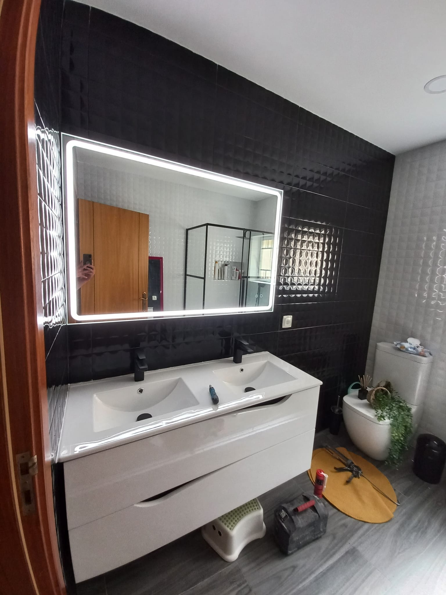 Casa de banho remodelada com móvel suspenso, lavatório duplo e espelho com iluminação LED