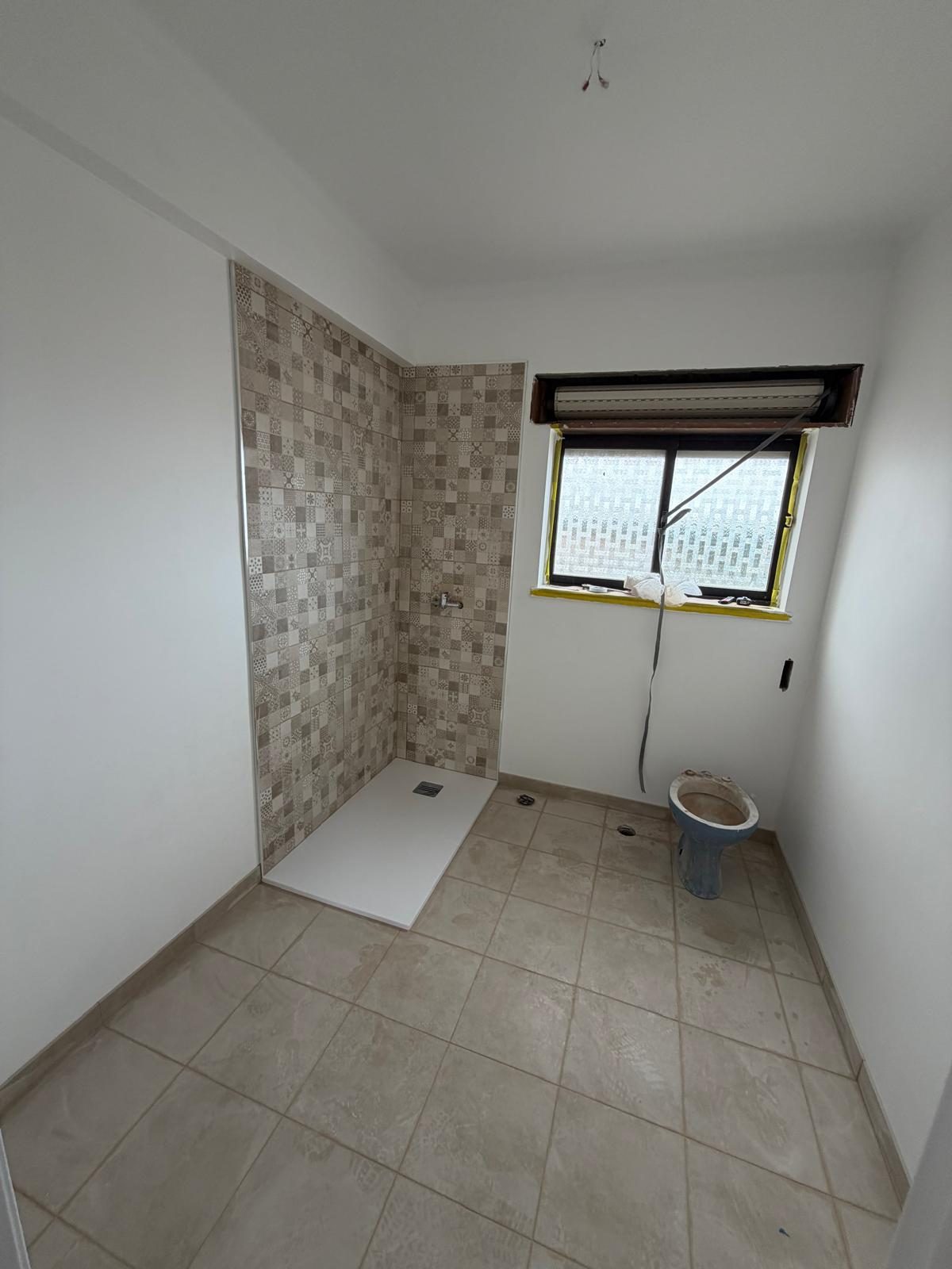 Casa de banho durante a obra, com o revestimento de parede já aplicado