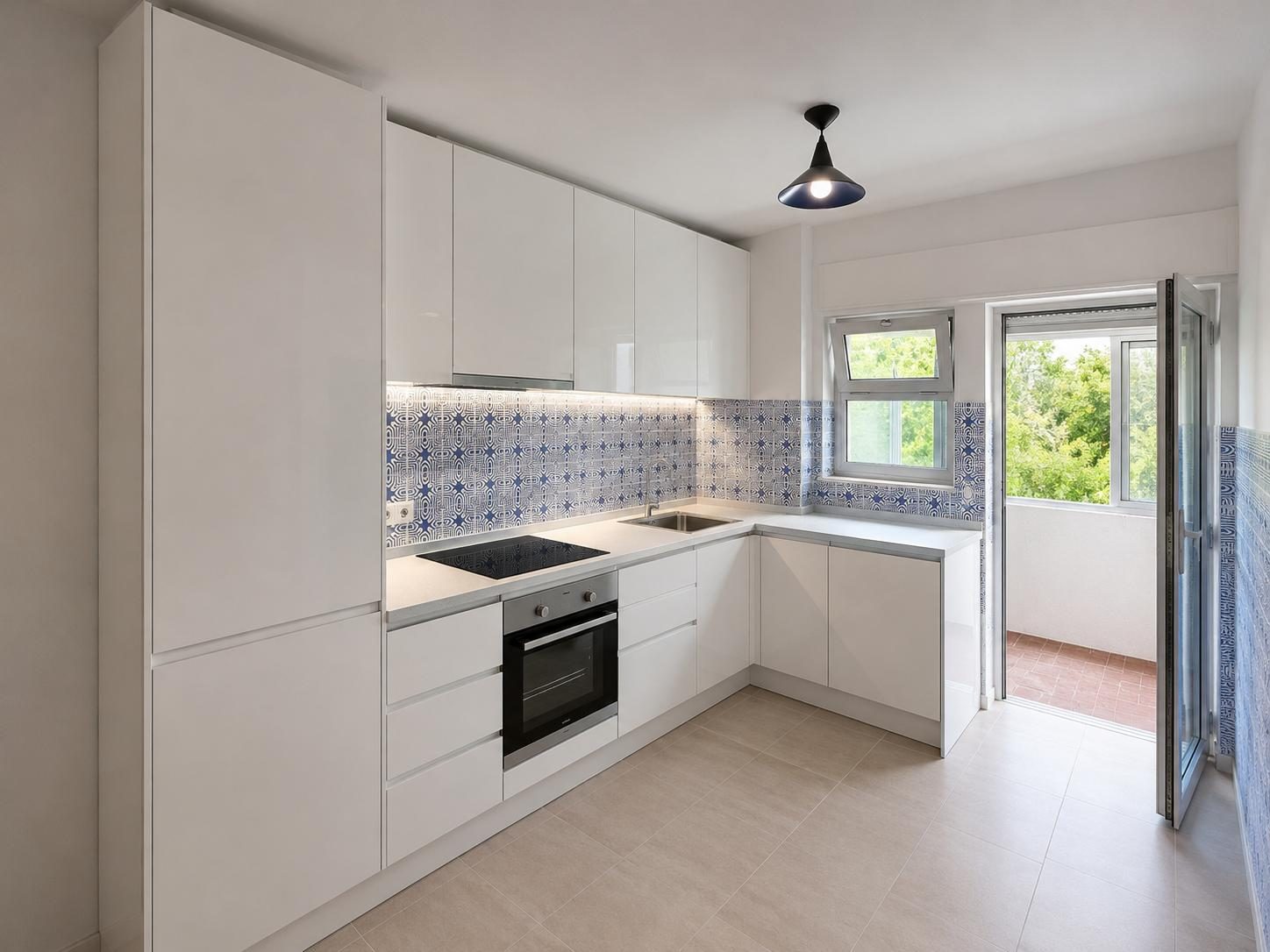 Cozinha remodelada com móveis lacados a branco e azulejo decorativo na bancada