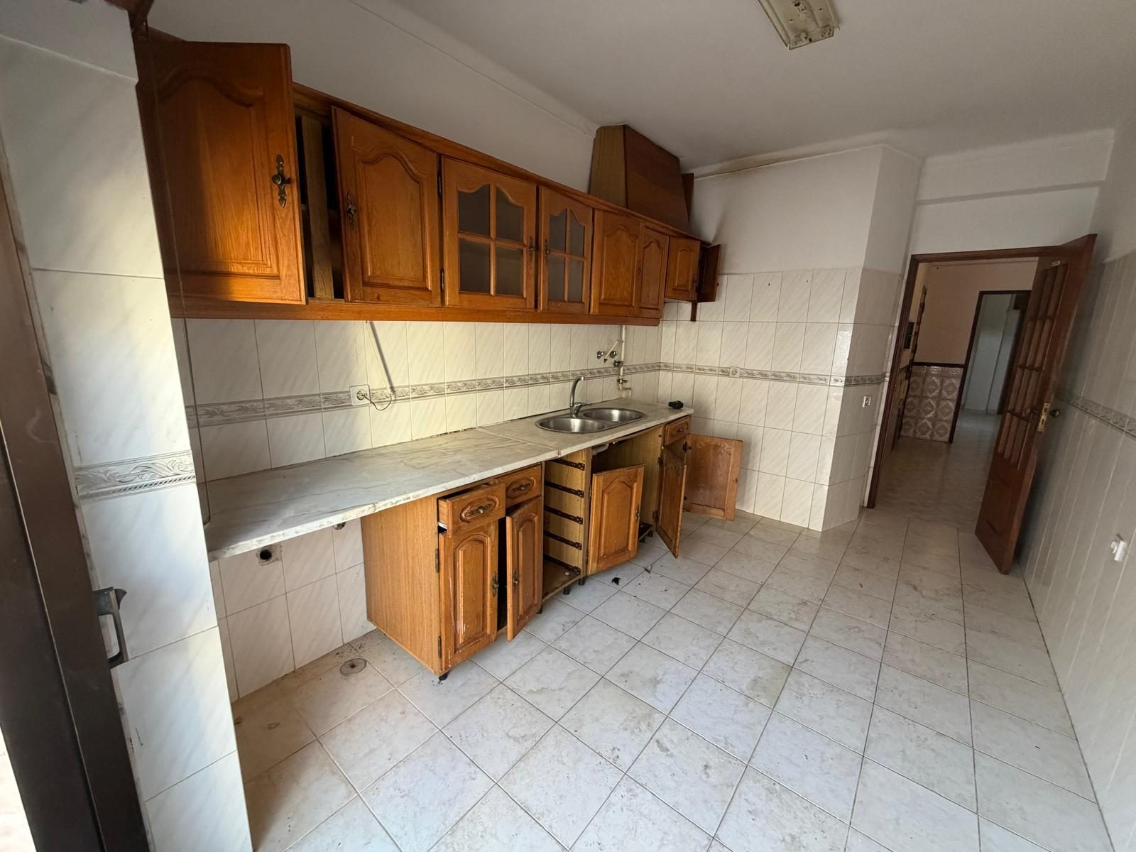 Cozinha antiga com móveis de madeira e azulejo dos anos 90, antes da intervenção