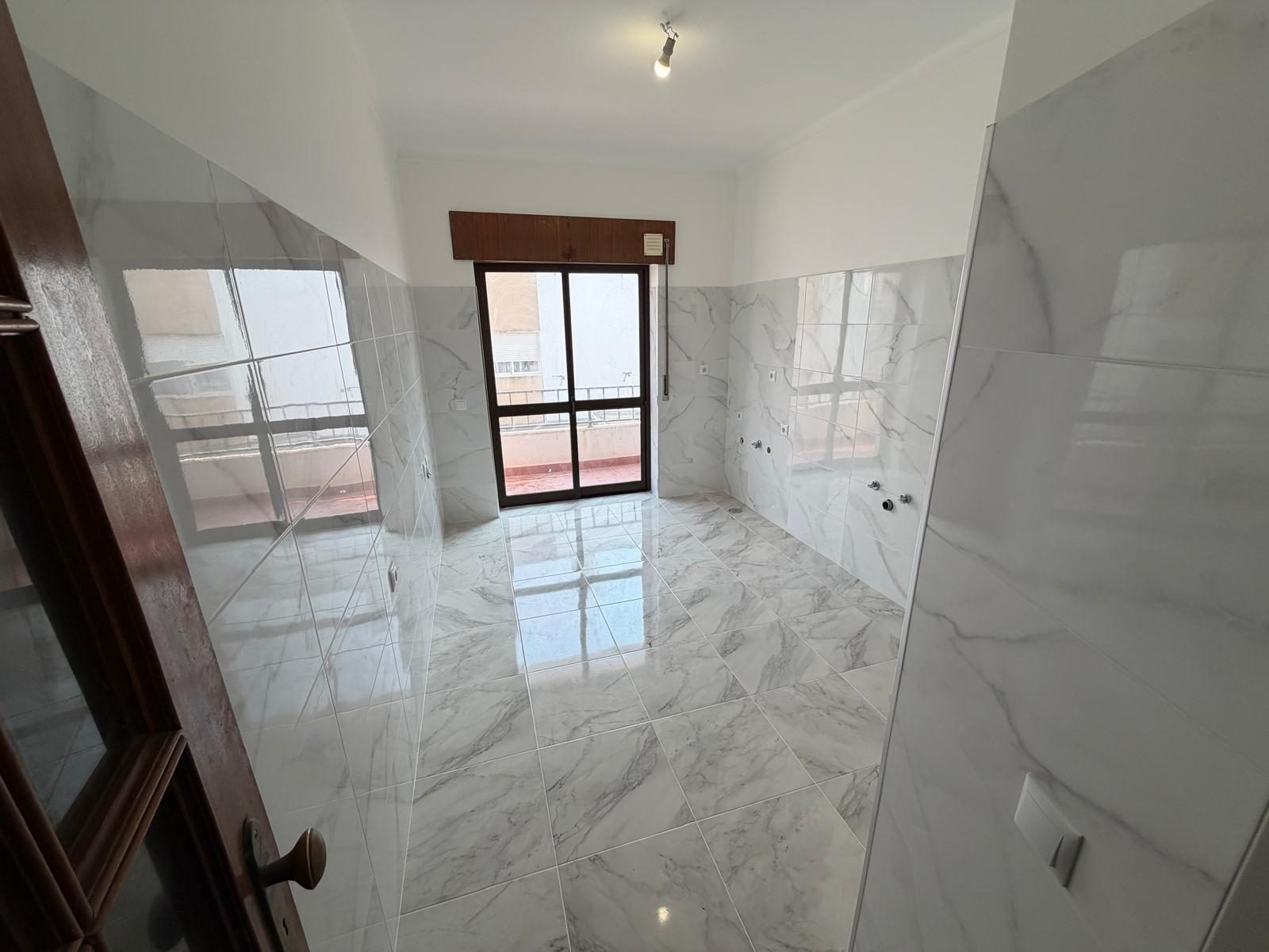 Zona de cozinha e sala com pavimento e revestimento efeito mármore