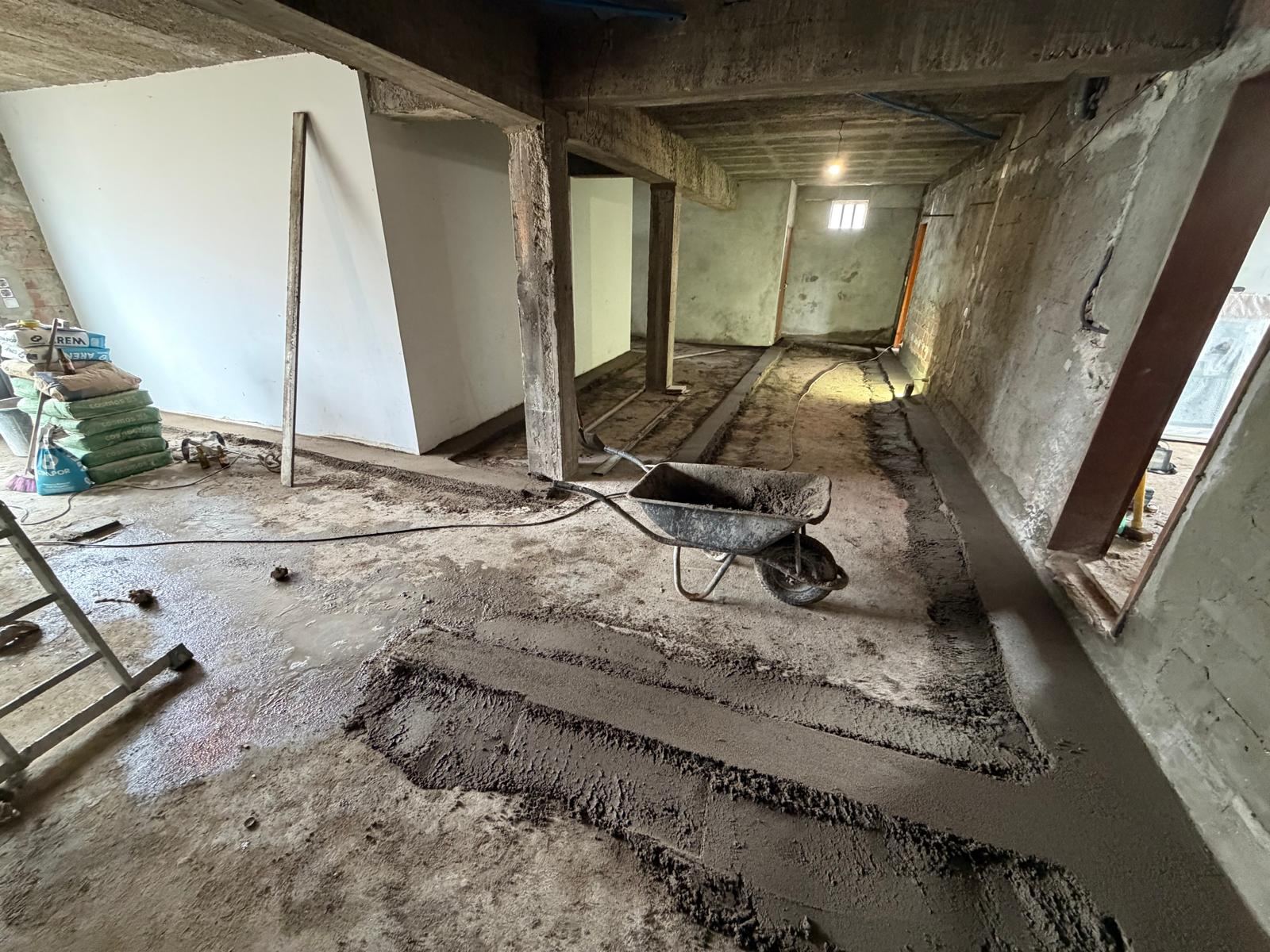 Interior de moradia em demolição, com paredes e pavimento removidos