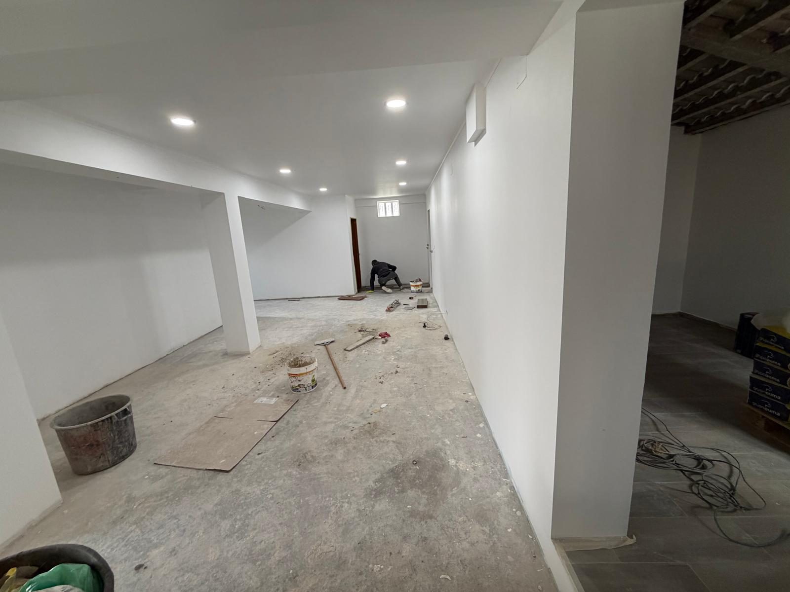 Interior da moradia com paredes acabadas e iluminação embutida no teto